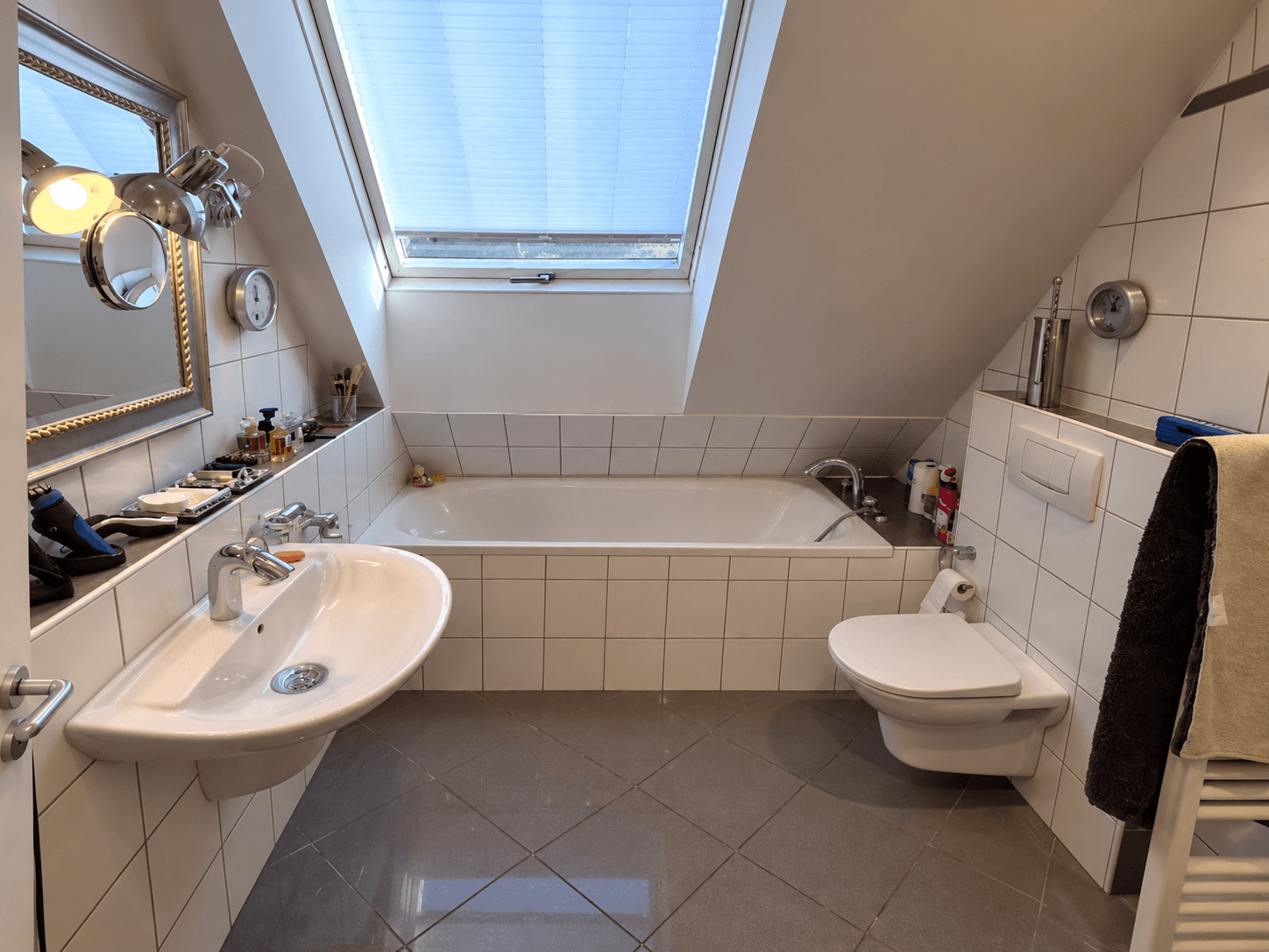 Klassisches Dachgeschossbad vor dem Umbau mit weißen Quadratfliesen und alter Badewanne